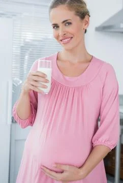 Cheerful expecting woman drinking milk Stock Photos