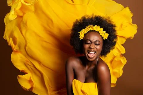 Cheerful Expression Afro American Model over Yellow Silk Flying Fabric on Wind Stock Photos