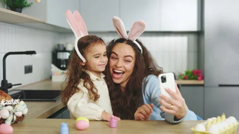 A cheerful family is preparing for the easter holiday using smartphone to video Stock Footage 230153889
