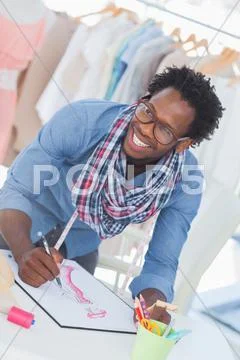 Cheerful fashion designer drawing clothes Stock-Fotos