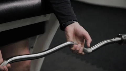 Cheerful fat man performs a wrong exercise in the gym. For the first time in a Stock Footage 105942717