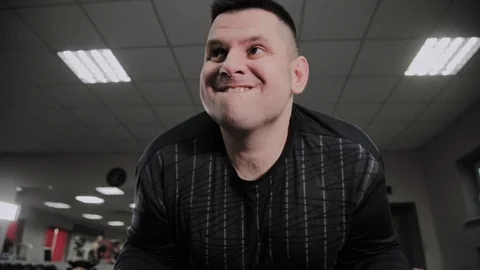 Cheerful fat man performs a wrong exercise in the gym. For the first time in a Stock Footage 105942811