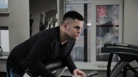 Cheerful fat man performs a wrong exercise in the gym. For the first time in a Stock Footage 105942974