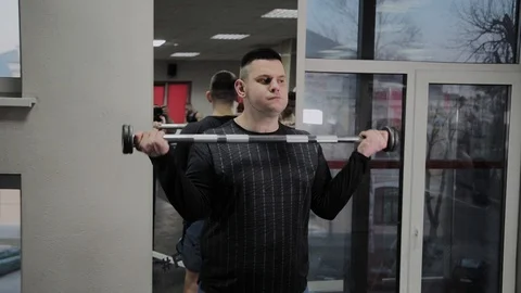 Cheerful fat man performs a wrong exercise in the gym. For the first time in a Stock Footage 105943002