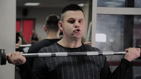 Cheerful fat man performs a wrong exercise in the gym. For the first time in a Stock Footage 105943038