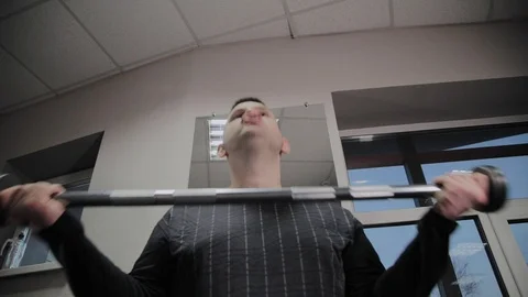 Cheerful fat man performs a wrong exercise in the gym. For the first time in a Stock Footage 105943124