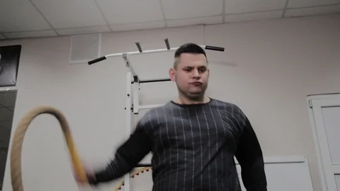 Cheerful fat man performs a wrong exercise in the gym. For the first time in a Stock Footage 105943397