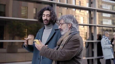Cheerful Father and son teaching how to use mobile phone. Business man walking Stock Footage 231581603