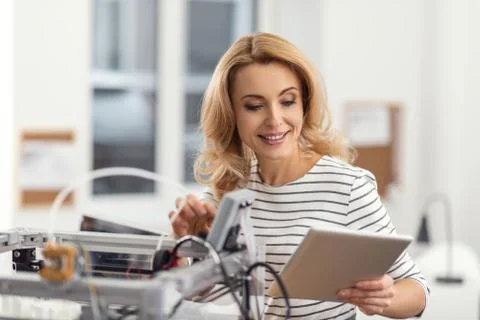 Cheerful female engineer programming 3D printer with tablet Stock Photos