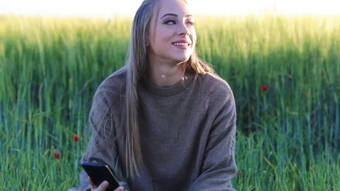 A cheerful female hiker using a mobile device, a smiling woman writing an ema Stock Footage 129811249