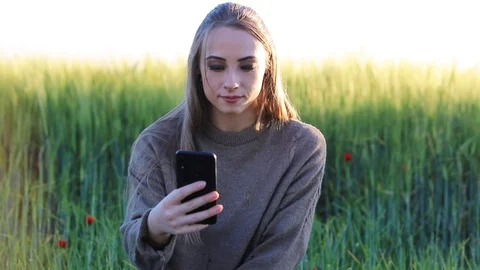 A cheerful female hiker using a mobile device, a smiling woman writing an ema Stock Footage 129811251