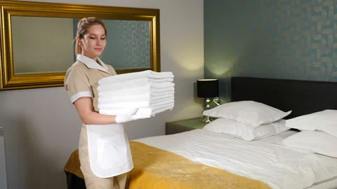 Cheerful female housekeeper holding stack of clean towels, laundry service Stock Footage 138739988