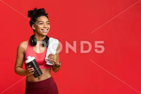 Cheerful fitness girl drinking protein during exercising Stock Photos