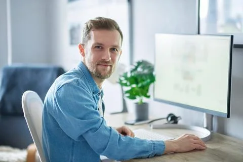 Cheerful freelance male software developer or IT support working at office Stock Photos