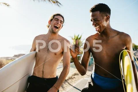 Cheerful friends going water surfing on holiday Stock Photos