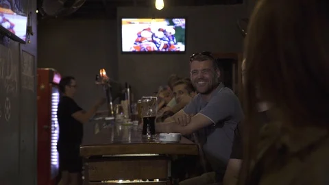 Cheerful friends having fun in pub bar and drinking beer together. Happy friends Stock Footage 104389004