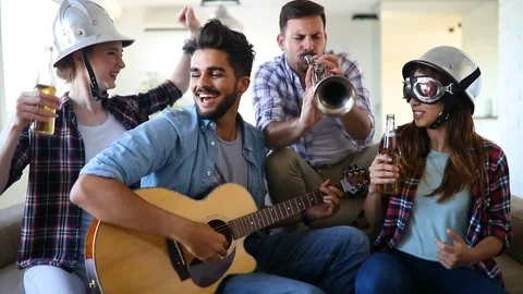 Cheerful friends having party together and playing instruments Stock Footage