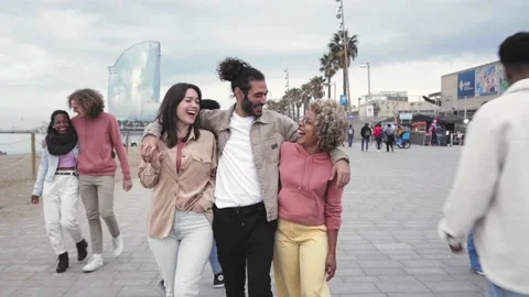 Cheerful friends walk through the crowd happily taking a stroll in the city of Stock Footage 169674147