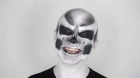 Cheerful funny man in skeleton make-up for Halloween smiles at the camera Vídeo Stock 139289771