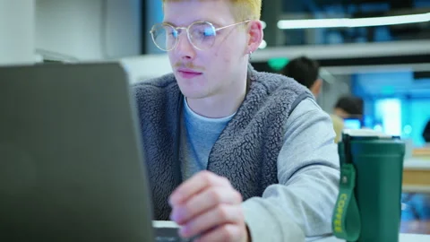 Cheerful Gen Z Man Using Laptop while Working in the Office Stock Footage 243957238