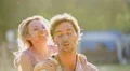 Cheerful girl jumping on boyfriend's back and kissing him, couple having fun 4k or 4k+ Resolution