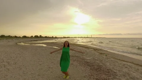 Cheerful Girl Jumping on a Sandy Seacoast in Slow Motion at sunset Stock Footage