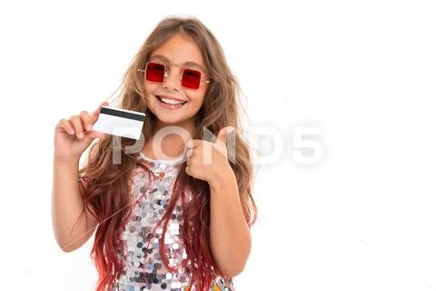 Cheerful girl in square red sunglasses holding plastic bank card and giving Stock Photos