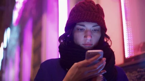 Cheerful girl texting using app on smart phone at night in city. Stock Footage 83072594