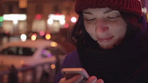Cheerful girl texting using app on smart phone at night in city. Video stock 83080326