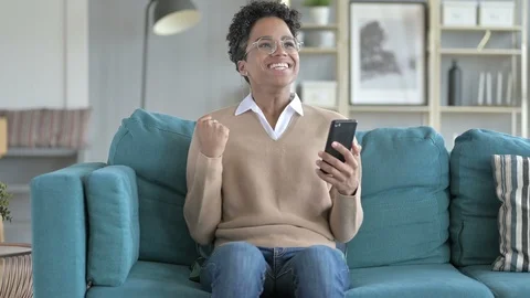 Cheerful Girl Using phone while Sitting on Couch Stock Footage 114782673