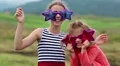 Cheerful girls in big glasses in the shape of stars looks at the camera HD Footage