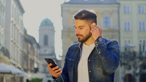 Cheerful good-looking bearded man in trendy jacket listening inflammatory music  Stock Footage 112355639