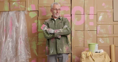 Cheerful grey haired man keeps hands crossed smiles gladfully does repair at Stock Footage 144914954