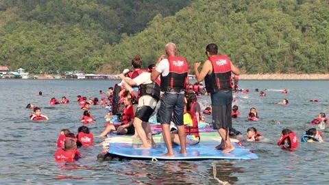 Cheerful group of Asian tourists having fun on floating raft Stock Footage 342519926
