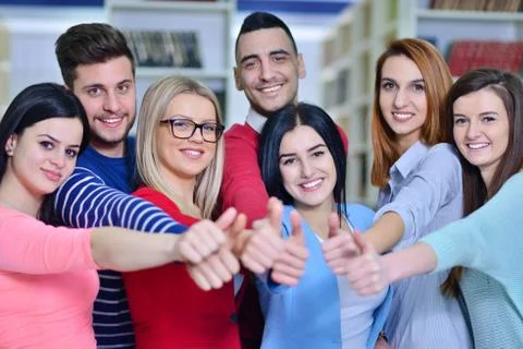 Cheerful group of students smiling at camera with thumbs up, success and 写真素材