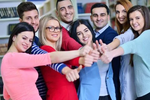 Cheerful group of students smiling at camera with thumbs up, success and Stock Photos