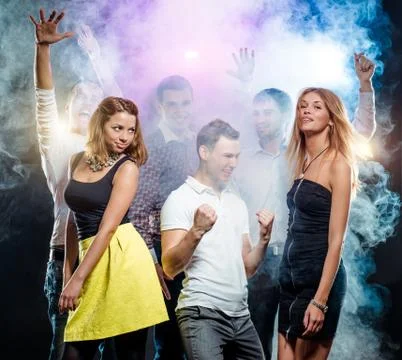 Cheerful group of young people dancing at party Stock Photos