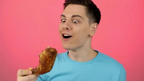 Cheerful guy eating grilled chicken. Hungry man Stock Footage 166560748