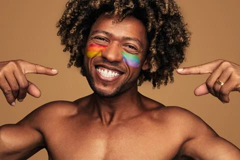 Cheerful guy with pride flags drawn on cheeks Stock Photos