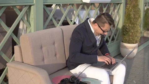 Cheerful guy quickly writes on laptop in cafe Stock Footage 87246958