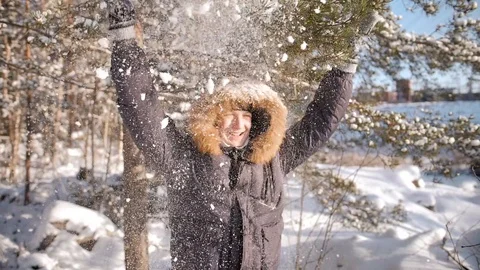 A cheerful guy shakes a snowy tree branch on his head Stock Footage 114691964