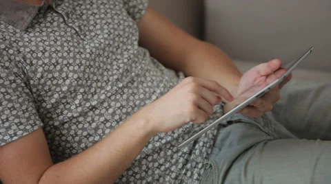Cheerful guy sitting on sofa using touchpad looking at camera and smiling Stock Footage 34278161