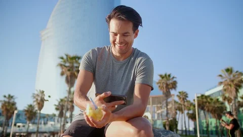 Cheerful guy smiling while watching interesting video content in new application Stock Footage 109419236