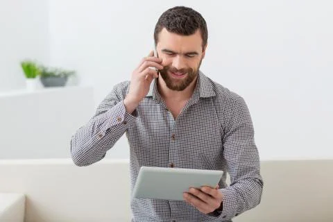Cheerful guy is working with modern technology Stock-Fotos