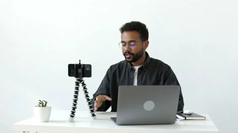 Cheerful handsome black skinned guy with eyeglasses recording vlog video online Stock Footage 196127333
