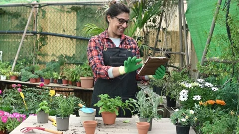 Cheerful Hispanic gardener using tablet Stock Footage 269345249