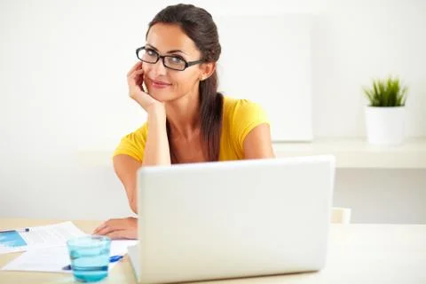 Cheerful hispanic worker with glasses using her computer in the office Stock Photos