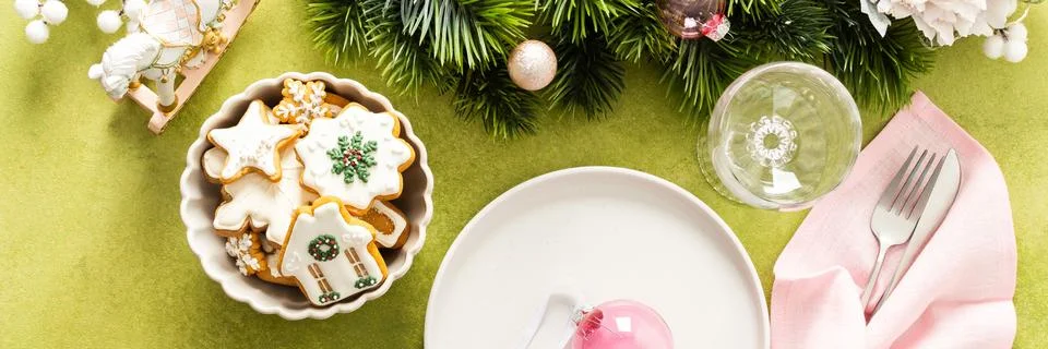 A cheerful holiday table setup featuring an empty plate, pink napkin, and cut Stock Photos