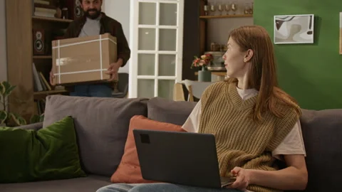 Cheerful Husband Bringing Flatpack Box with New Furniture Home to Wife Stock Footage 330512024