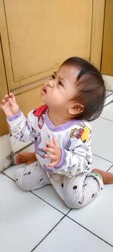 Cheerful Indonesian Toddler Exploring Sunny Porch Stock Photos